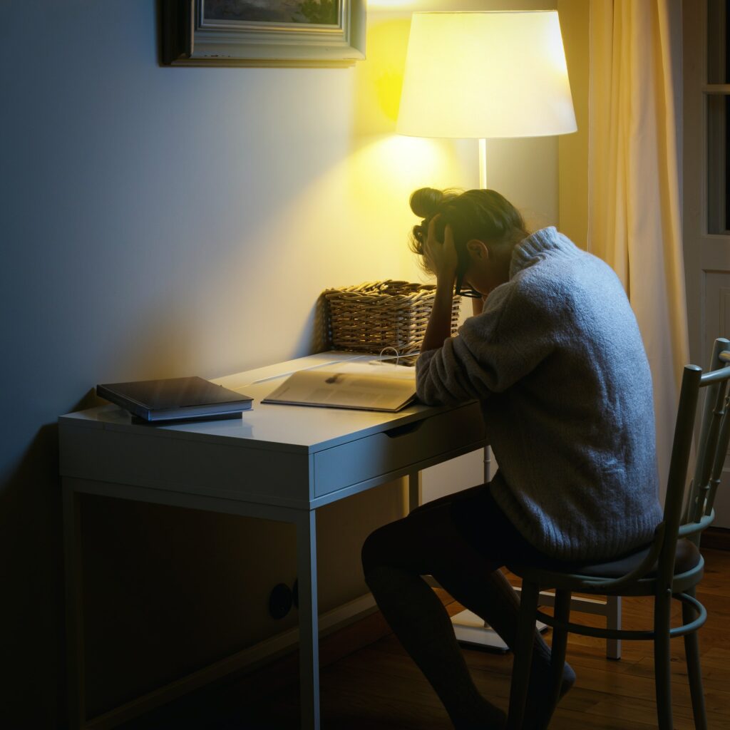 Student with headache after long studying and reading books
